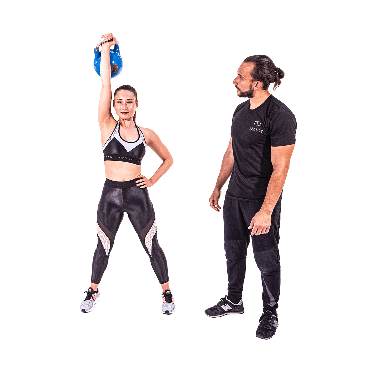 Lizzy lifts up a kettlebell while kevin coaches.